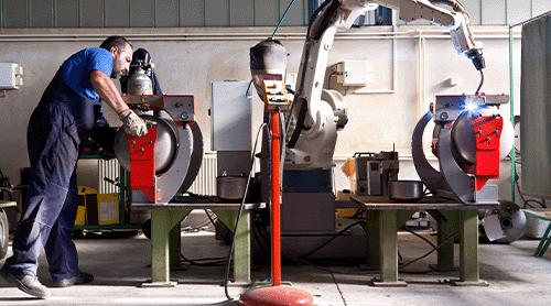 Mens en robotmachine werken samen in industrieel gebouw