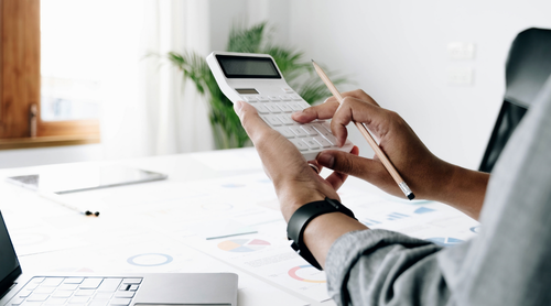 Close up businessman hand using calculator and working with laptop calculate about finance accounting at coffeeshop outdor.finance accounting concept